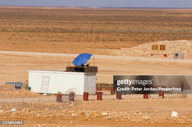 Armed guards on sentry duty outside a compound housing Bechtel construction workers building the Maghreb-Europe Gas Pipeline in the desert interior...
