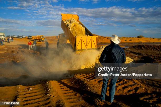 Workers watch a truck backfilling a trench containing sealed and completed pipe sections during construction of the Maghreb-Europe Gas Pipeline in...