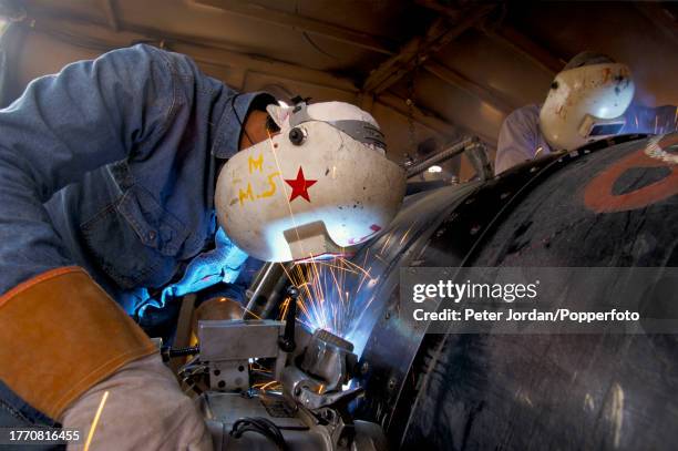Worker welds joints on a pipe section during construction of the Maghreb-Europe Gas Pipeline in the desert interior of Algeria in September 1995. The...