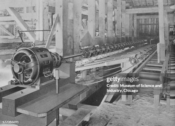 Electronically Driven Saw Mills - Cut 17272 - black and white image of the interior of a sawmill, showing a long Pacific Coast Overhead Trimmer, 1922.