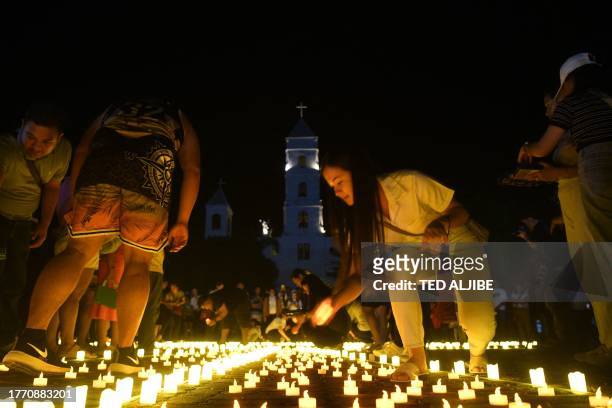 People place LED candles during a vigil in memory of Super Typhoon Haiyan victims on the tenth anniversary of the disaster at a park in Tacloban...