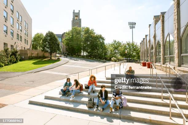grupo de estudiantes universitarios sentados en los escalones de un edificio de la facultad - campus fotografías e imágenes de stock