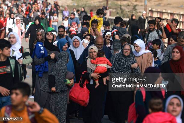 Palestinians fleeing Gaza City and other parts of northern Gaza towards the southern areas, walk on a road on November 8, 2023 amid the ongoing...