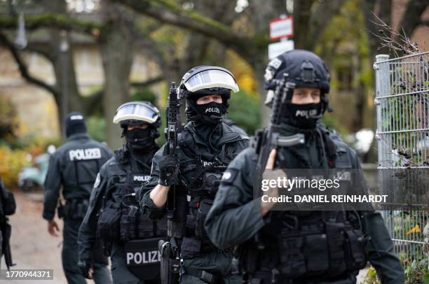 Armed policemen stand outside a school in the Blankenese district of Hamburg, northern Germany, on November 8, 2023. Police evacuated students from...