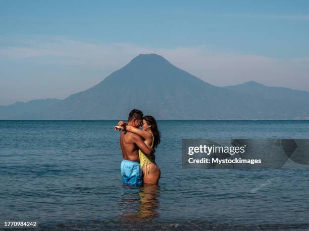 multiracial couple swimming in the lake - lake atitlan stock pictures, royalty-free photos & images