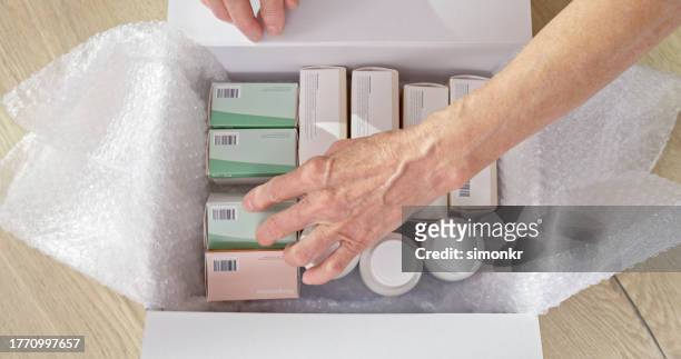 woman opening pharmacy box - elderly receiving paperwork stock pictures, royalty-free photos & images