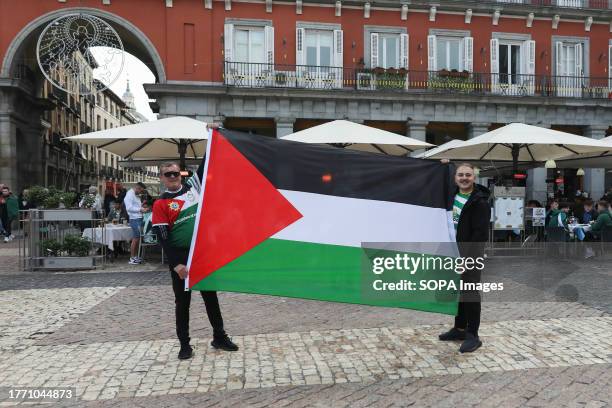 Couple of Celtic fans from Scotland carry a Palestinian flag in the main square of Madrid, where the Scottish fans have gathered hours before the...