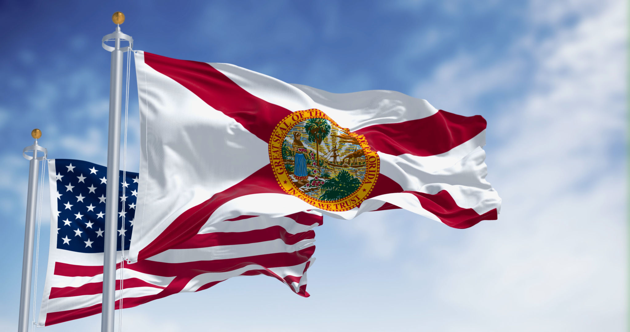 Flags of Florida and United States waving in the wind on a clear day Flags of Florida and United States waving in the wind on a clear day