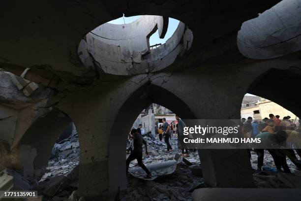 Palestinians inspect the debris at the Khaled Ibn Al-Walid mosque, after it was hit by Israeli bombardment, in Khan Yunis on November 8 amid ongoing...
