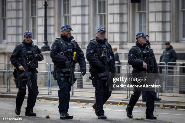 Armed Police officers carrying rifles and taser guns along Whitehall after the official State Opening of Parliament at The Houses of Parliament, for...