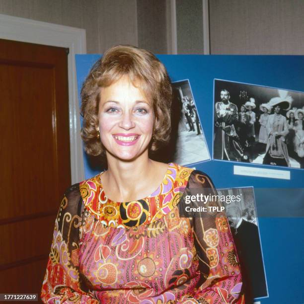 Portrait of English actress Sylvia Syms as she poses in front of a poster of various photographs, London, England, October 4, 1971.