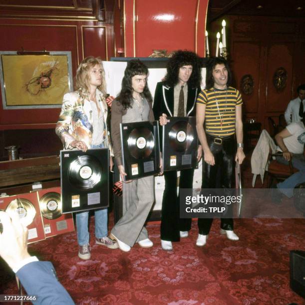 View of members of the Rock and Pop group Queen during an award presentation at Les Ambassadeurs Club, London, England, September 8, 1976. Pictured...