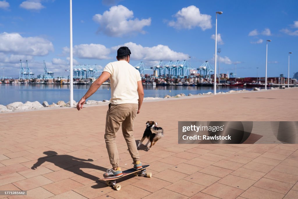 Man skating with his dog at full speed.