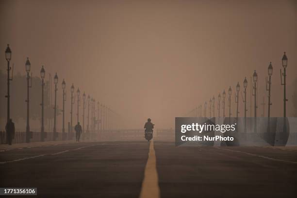 Man rides his scooter on Kartavya Path on a smoggy morning in New Delhi, India on November 8, 2023.