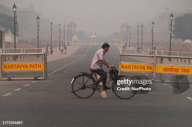 Man rides his cycle on Kartavya Path on a smoggy morning in New Delhi, India on November 8, 2023.