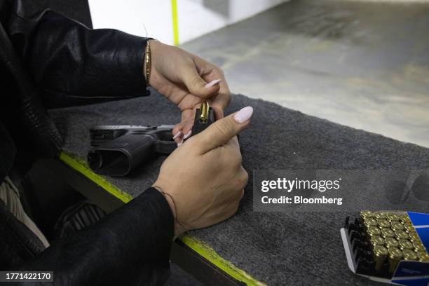 Participant loads a magazine with bullets during a training session at a shooting range in Pompano Beach, Florida, US, on Wednesday, Oct. 25, 2023....