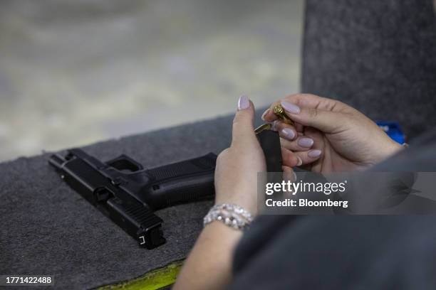 Participant loads a magazine with bullets during a training session at a shooting range in Pompano Beach, Florida, US, on Wednesday, Oct. 25, 2023....