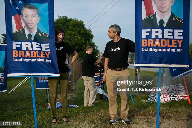 Emma Cape, left, and Patrick ConwayÊhold up signs as protesters with the Bradley Manning Support Network hold a vigil while waiting to hear Manning's...