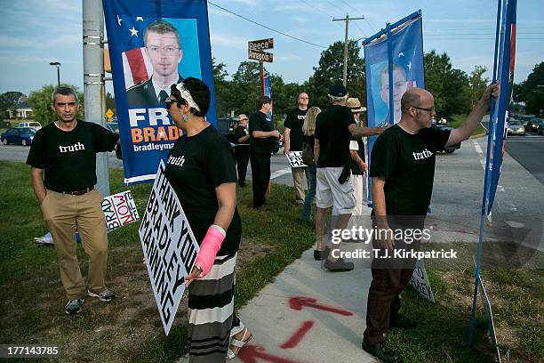 Protesters with the Bradley Manning Support Network hold a vigil while waiting to hear Manning's sentence on August 21, 2013 outside the gate of Fort...