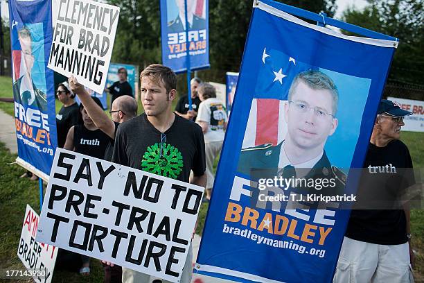 Protesters with the Bradley Manning Support Network hold a vigil while waiting to hear Manning's sentence on August 21, 2013 outside the gate of Fort...