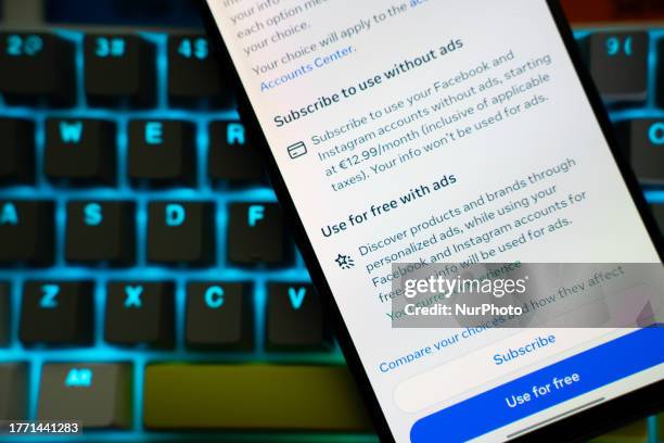 Mobile phone over a keyboard is seen, showing the message that appeared in Facebook users for the new subscription plans regarding ads.
