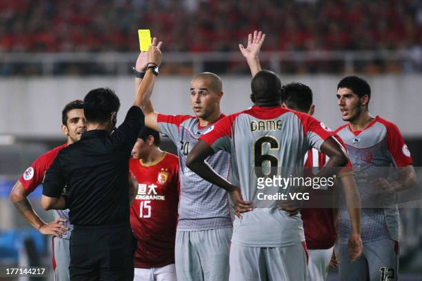 Madjid Bougherra of Lekhwiya is shown a yellow card by referee Dong-Jin Kim during the AFC Champions League quarter-final match between Guangzhou...