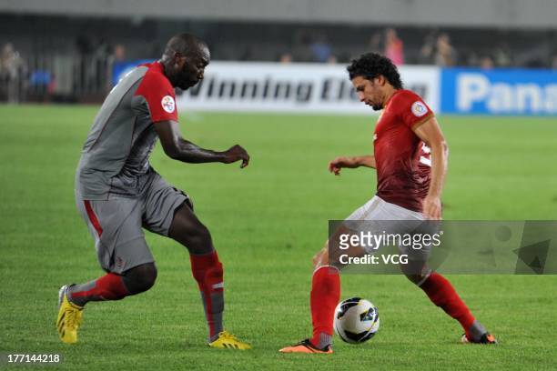 Elkeson of Guangzhou Evergrande and Dame Traore of Lekhwiya battle for the ball during the AFC Champions League quarter-final match between Guangzhou...
