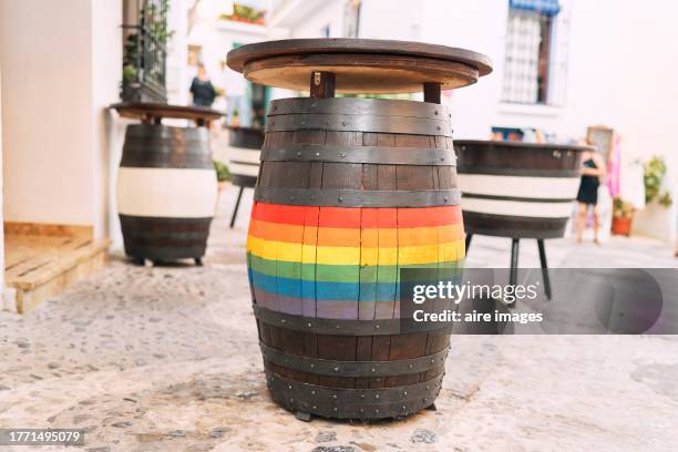 close-up of barrels with table on top, one of them painted as a rainbow outside a bar or restaurant, front view - whiskey sour stock pictures, royalty-free photos & images