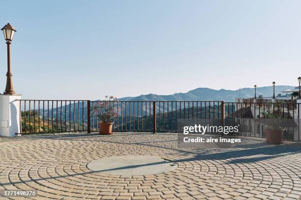 front view of an empty veranda without people with a handrail and light poles on one side. - balustrade stock pictures, royalty-free photos & images