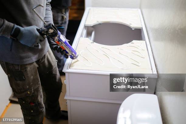 contractors working on bathroom remodel - caulk gun stock pictures, royalty-free photos & images