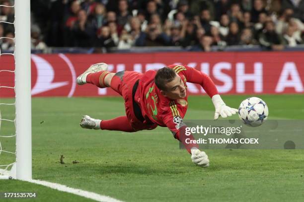 Real Madrid's Ukrainian goalkeeper Andriy Lunin stops the ball during the UEFA Champions League group C football match between Real Madrid CF and SC...