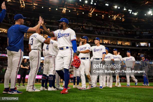 Adolis Garcia of the Texas Rangers high fives teammates to celebrate a victory over the Los Angeles Angels after a game at Globe Life Field on August...