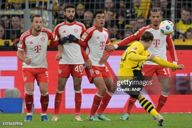 Marcel Sabitzer of Borussia Dortmund takes a free kick Harry Kane of FC Bayern Munchen, Noussair Mazraoui of FC Bayern Munchen, Jamal Musiala of FC...