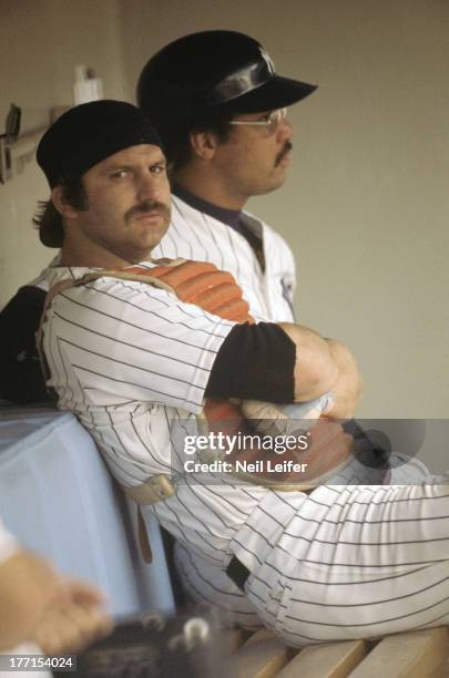 New York Yankees Thurman Munson wearing catcher's equipment and Reggie Jackson in dugout during game vs Toronto Blue Jays at Yankee Stadium. Bronx,...