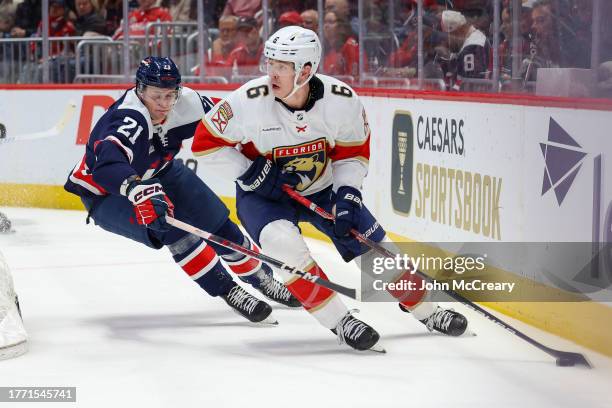 Mike Reilly of the Florida Panthers protects the puck as he is pressured by Aliaksei Protas of the Washington Capitals during a game at Capital One...