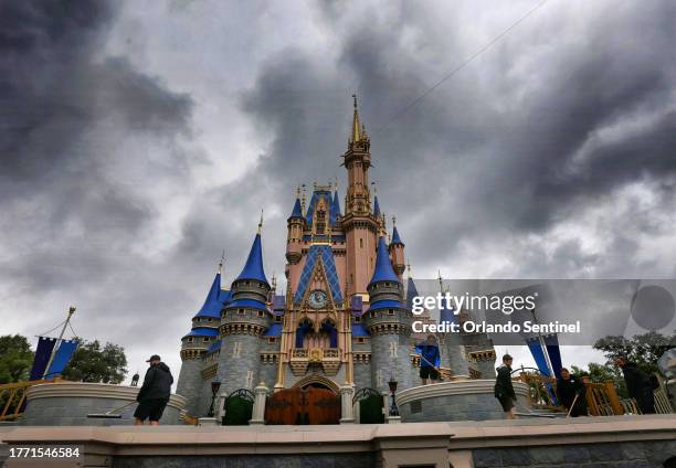Cast members squeegee the stage in front of Cinderella Castle as rain bands pass through the Magic Kingdom at Walt Disney World, in Lake Buena Vista,...