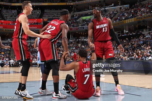 Bam Adebayo and Jimmy Butler of the Miami Heat help up Kyle Lowry during the game against the Memphis Grizzlies on November 8, 2023 at FedExForum in...