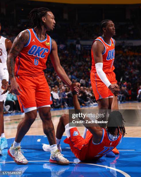 Isaiah Joe of the Oklahoma City Thunder is helped up by Jaylin Williams and Jalen Williams during the game against the Cleveland Cavaliers on...