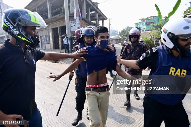 Rapid Action Battalion personnel detain a garment worker protesting in Gazipur on November 9 after the Minimum Wage Board authority declared the...