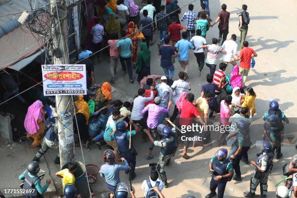 Bangladeshi security personnel charge to disperse garment workers protesting in Gazipur on November 9 after the Minimum Wage Board authority declared...