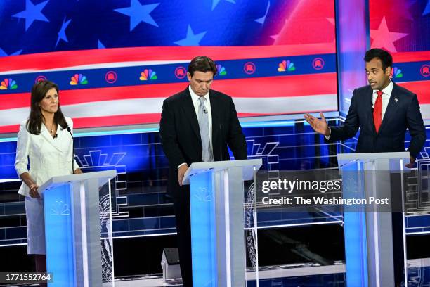 Businessman Vivek Ramaswamy talks to former United Nations Ambassador Nikki Haley, with Florida Gov. Ron DeSantis in the middle, during the...