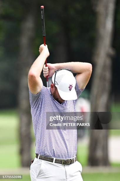 S Talor Gooch scratches his back with his club on day one of the Hong Kong Open golf tournament at Fanling Golf Course in Hong Kong on November 9,...