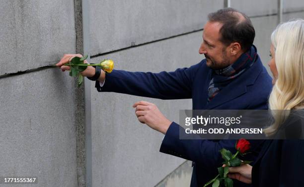 Crown Prince Haakon of Norway and Crown Princess Mette-Marit of Norway place roses in the wall during festivities at the Berlin Wall Memorial, a 1,5...