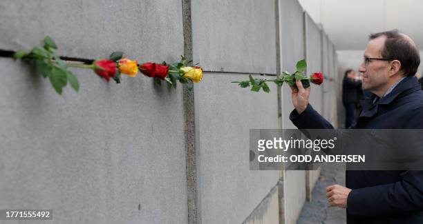 Norway's Foreign Minister Espen Barth Eide places a rose in the wall during festivities at the Berlin Wall Memorial, a 1,5 kilometers stretch on the...
