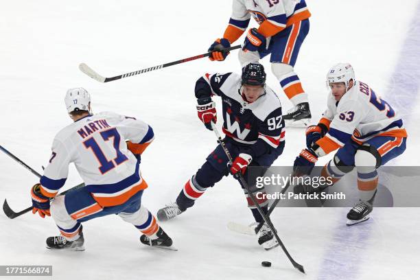 Evgeny Kuznetsov of the Washington Capitals skates past Casey Cizikas and Matt Martin of the New York Islanders during the first period at Capital...