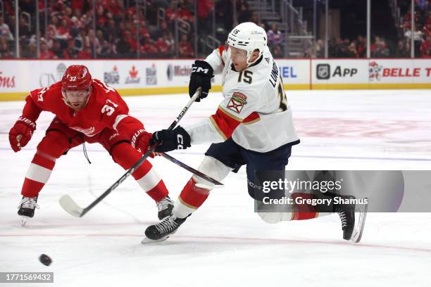 Anton Lundell of the Florida Panthers takes a first period shot past the stick of J.T. Compher of the Detroit Red Wings at Little Caesars Arena on...