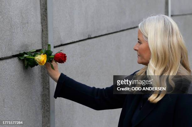Crown Princess Mette-Marit of Norway places a rose in the wall during festivities at the Berlin Wall Memorial, a 1,5 kilometers stretch on the former...