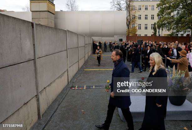 Crown Prince Haakon of Norway and Crown Princess Mette-Marit of Norway prepare to place roses in the wall during festivities at the Berlin Wall...