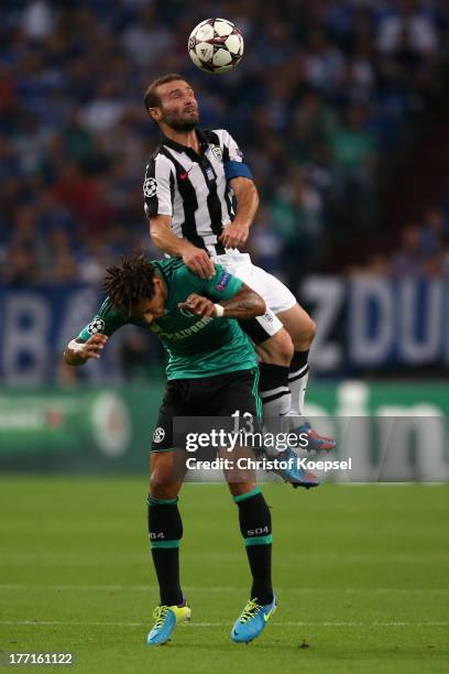 Jermaine Jones of Schalke and Dimitris Salpingidis of Saloniki go up for a header during the UEFA Champions League Play-off first leg match between...