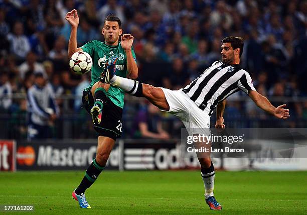 Adam Szalai of Schalke is challenged by Alexandros Tziolis of Saloniki during the UEFA Champions League Play-off first leg match between FC Schalke...